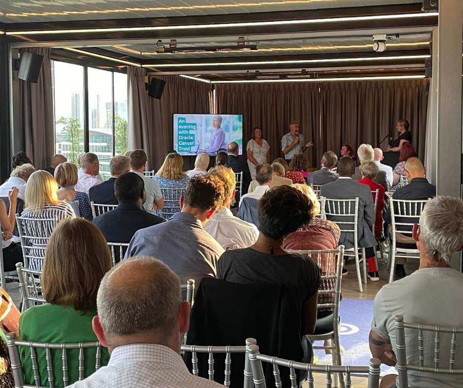 Event photo with room filled with people sitting listening to panel discussion