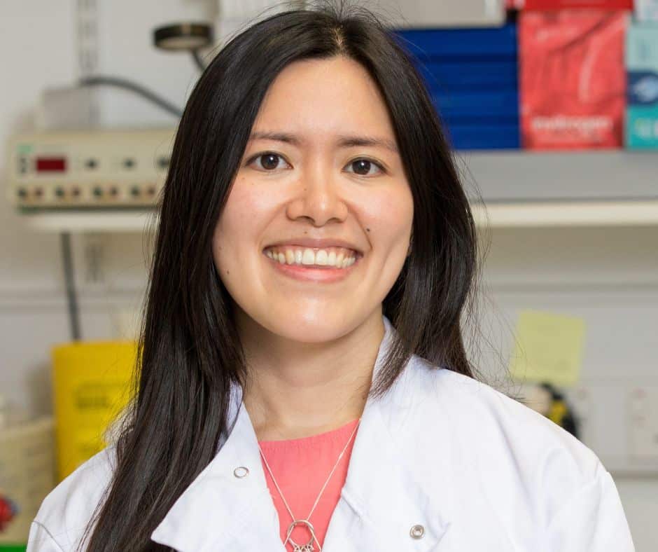 Charleen Chan smiling into camera with lab coat on