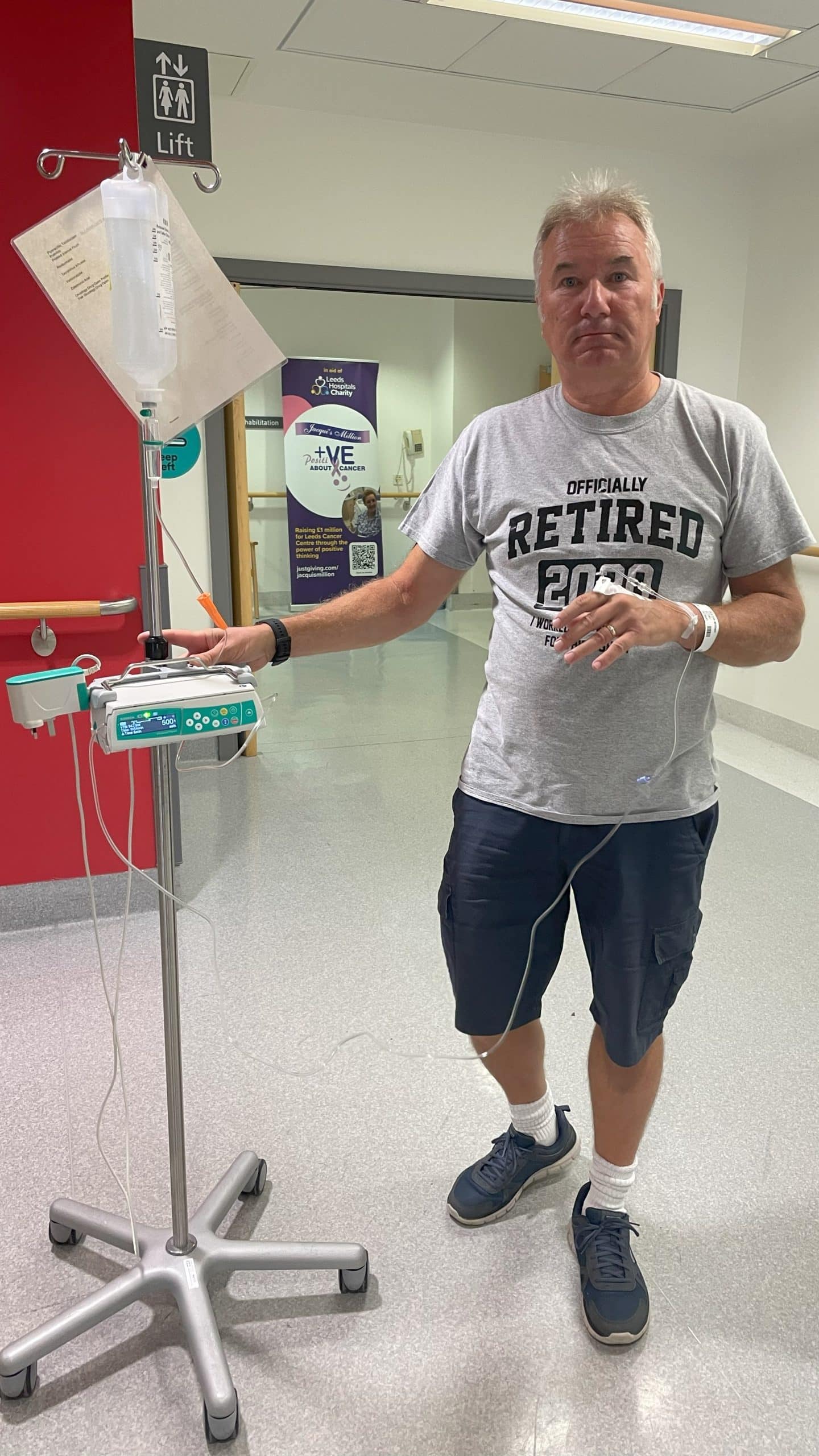 Patient wheeling his chemotherapy drip on the ward.